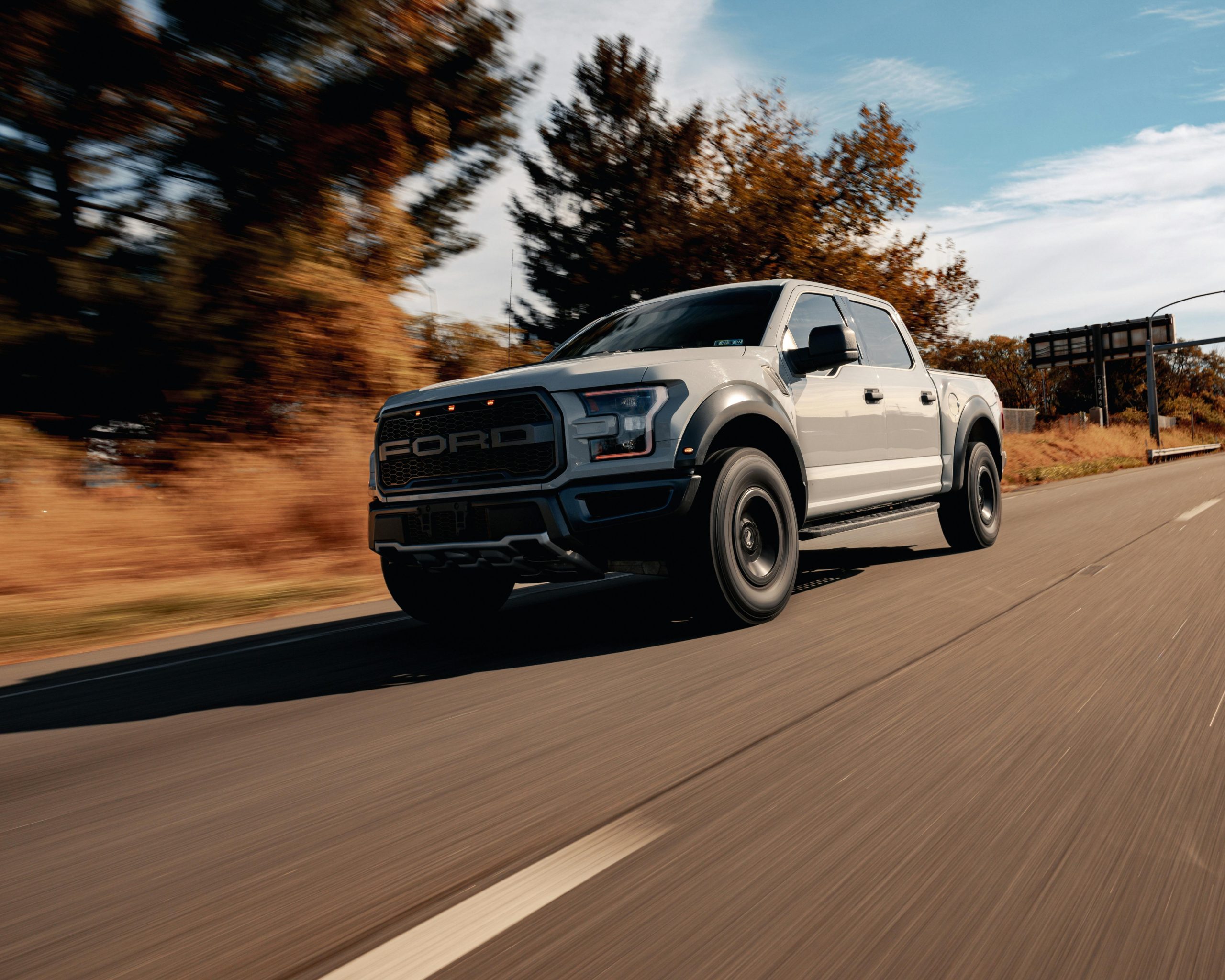Silver Ford F-150 pickup truck driving on a road